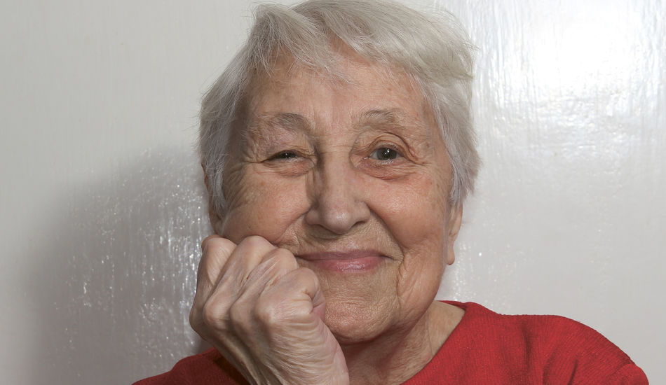 Ältere Dame sieht in die Kamera und lächelt