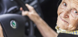 Pensionistin sitzt am Steuer im Auto