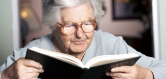 Ältere Person liest in einem Buch